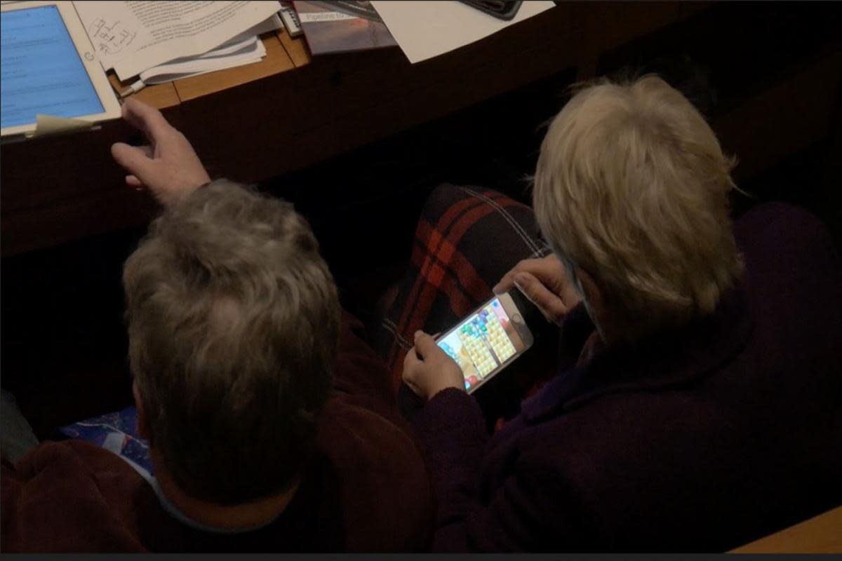 Cllr Lishman apparently playing Candy Crush on her mobile phone in a council meeting <i>(Image: Jamie McGowan)</i>