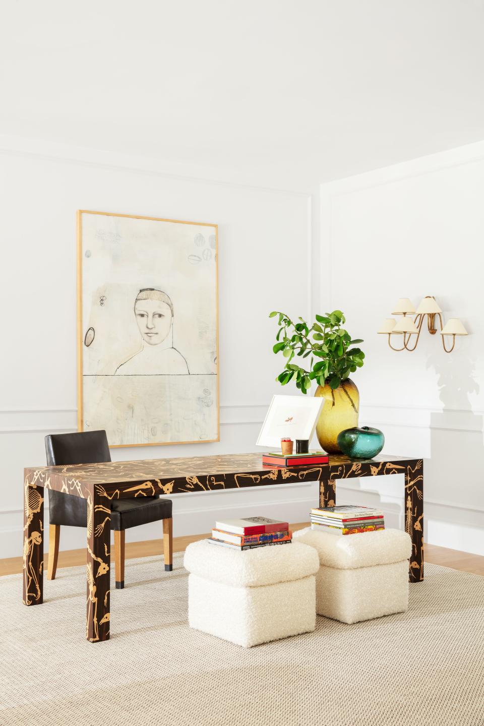 A Richard Prince work hangs behind a Studio Job desk in the living room. The stools wear a Zak + Fox wool-blend; Royère sconce; Warhol artwork (on desk).