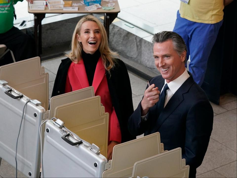 Jennifer Siebel Newsom and her husband Gavin Newsom pause as they spot photographers while voting in Sacramento on 8 November 2022 (AP Photo/Rich Pedroncelli)