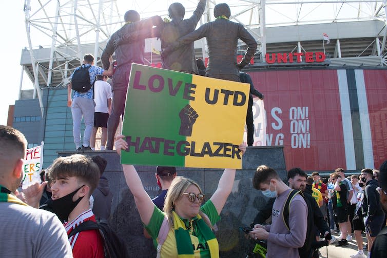 Protestor with anti-Glazer placard.