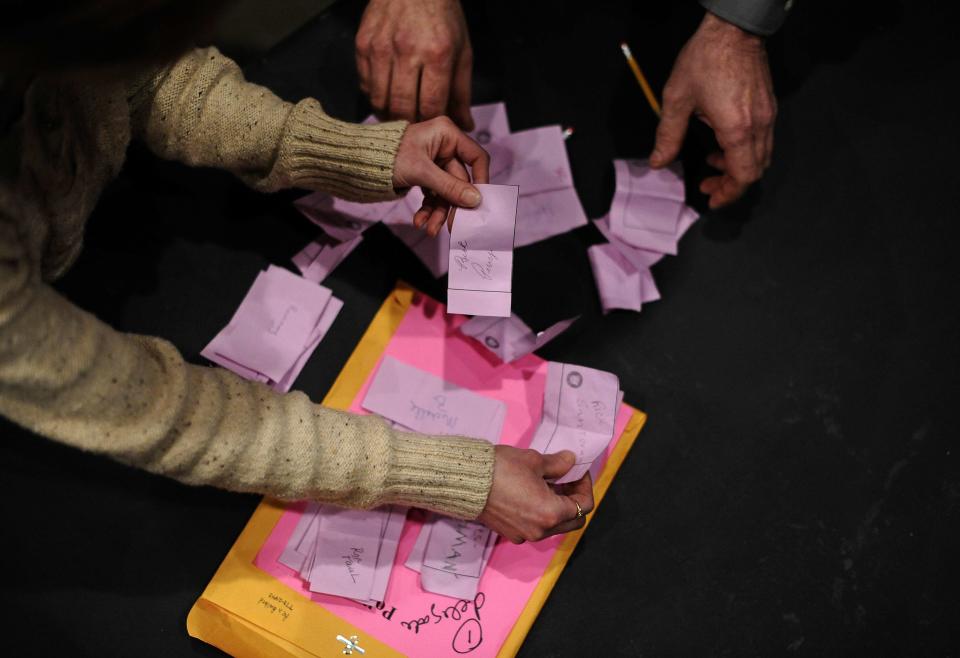 Electoral personnel and volunteers count ballots during Republican caucues at a school in Des Moines, Iowa, in January 2012.