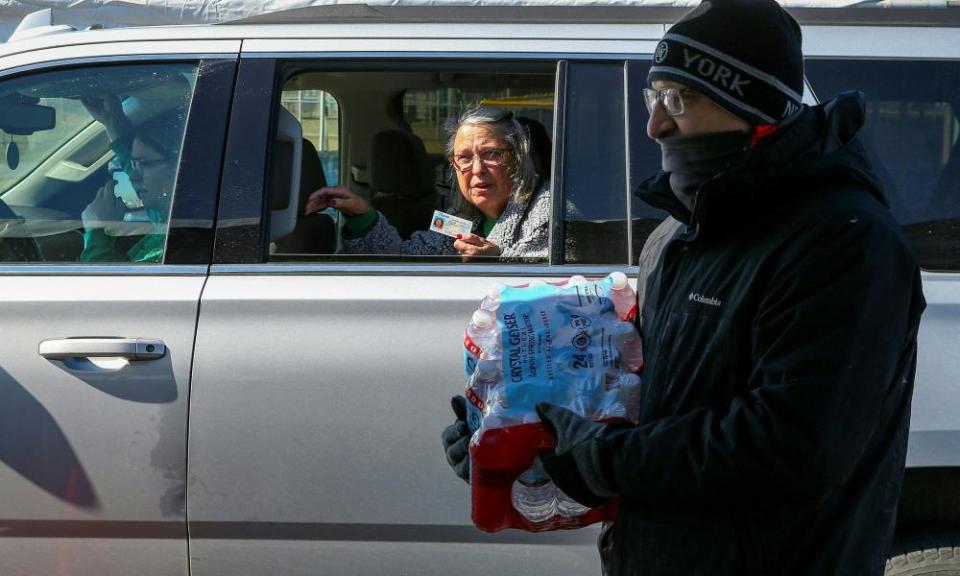 Volunteers hand out cases of water bottles at the Schlitterbahn Waterpark parking lot in Galveston, Texas.