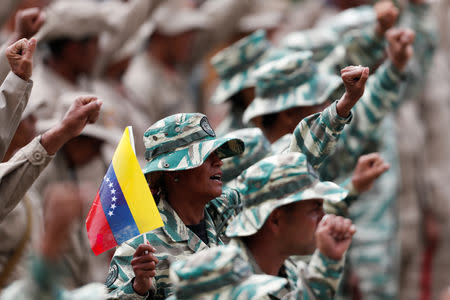 Militia members take part in a ceremony to mark the 17th anniversary of the return to power of Venezuela's late President Hugo Chavez after a coup attempt and the National Militia Day in Caracas, Venezuela April 13, 2019. REUTERS/Carlos Garcia Rawlins