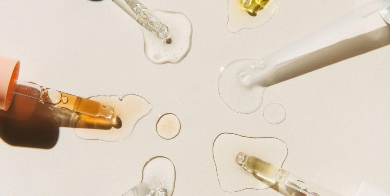 pipettes with drops of cosmetic liquid on beige background