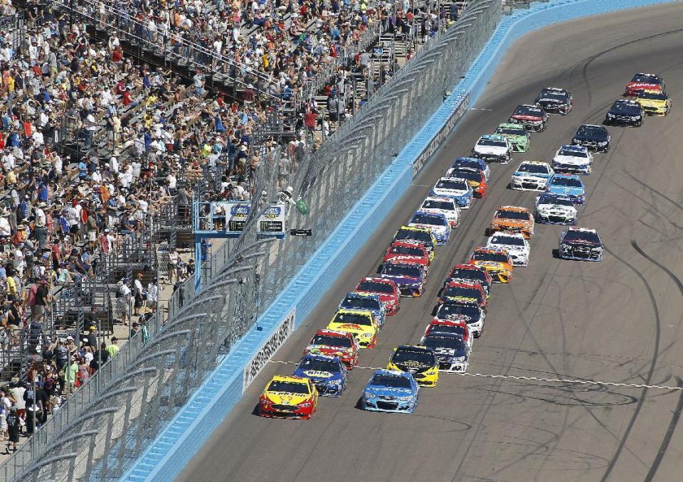 Pole-sitter Joey Logano, left, and Kyle Larson, right, lead the field on a re-start during the NASCAR Cup Series auto race at Phoenix International Raceway, Sunday, March. 19, 2017, in Avondale, Ariz. (AP Photo/Ralph Freso)