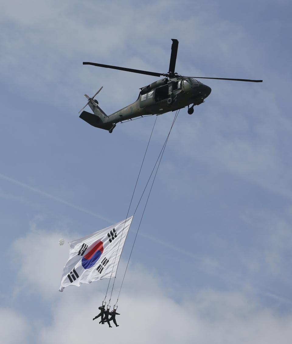 Members of the Special Warfare Command hang suspended from an army helicopter during celebrations to mark the 65th anniversary of Korea Armed Forces Day, at a military airport in Seongnam, south of Seoul, October 1, 2013. (REUTERS/Kim Hong-Ji)