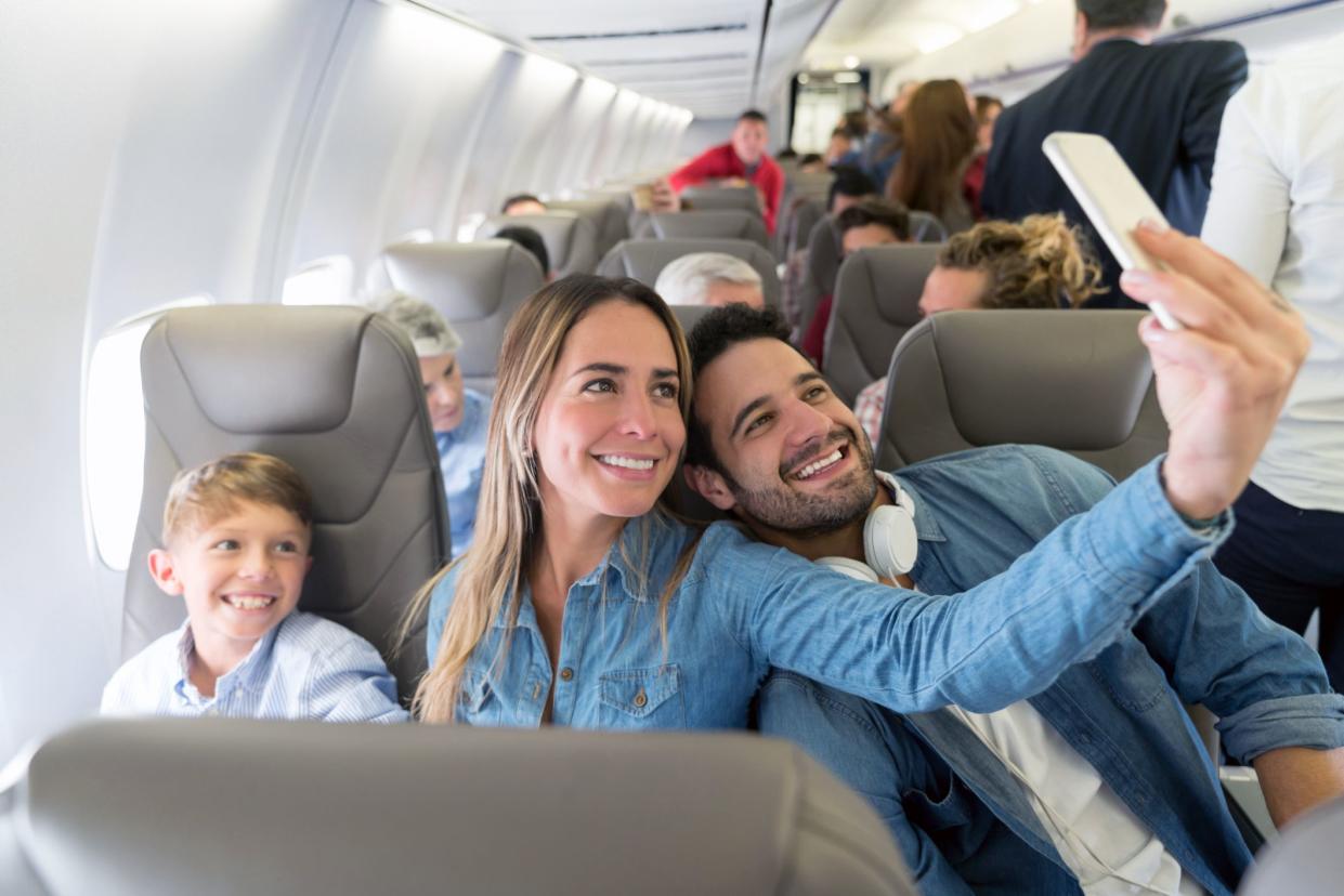 family taking selfie together in same airplane seat