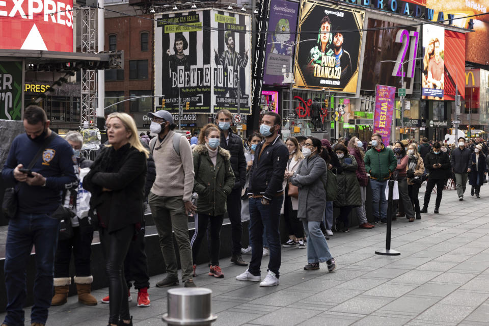 People wait in line to get tested for COVID-19 at a mobile testing site in Times Square on Friday, Dec. 17, 2021, in New York. New York City had been mostly spared the worst of the big surge in COVID-19 cases that has taken place across the northeastern and midwestern U.S. since Thanksgiving, but the situation has been changing rapidly in recent days.(AP Photo/Yuki Iwamura)