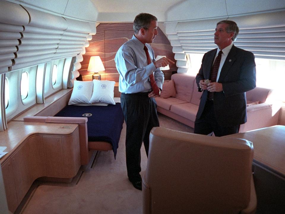 President George W. Bush talks with his chief of staff aboard Air Force One.