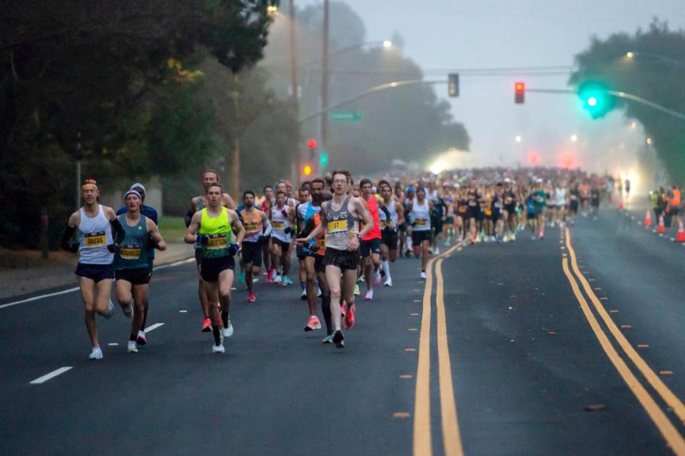 Runners pass Inwood Road in Folsom after the start of the 2021 California International Marathon on Sunday, Dec. 5, 2019.