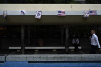 A man walks past posters left by protesters in Hong Kong, Tuesday, Oct. 15, 2019. A homemade, remote-controlled bomb intended to "kill or to harm" riot control officers was detonated as they deployed against renewed violence in Hong Kong over the weekend, police said Monday, in a further escalation of destructive street battles gripping the business hub. (AP Photo/Vincent Yu)