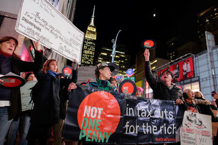 Demonstrators take part in a protest against tax cuts for rich people as the Empire State Building is seen at the background in the Manhattan borough of New York City, New York, U.S., November 27, 2017. REUTERS/Eduardo Munoz
