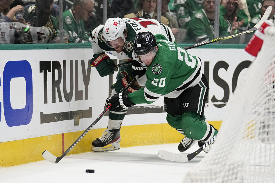 Minnesota Wild left wing Marcus Foligno (17) and Dallas Stars defenseman Ryan Suter (20) compete for control of the puck in the second period of Game 2 of an NHL hockey Stanley Cup first-round playoff series, Wednesday, April 19, 2023, in Dallas. (AP Photo/Tony Gutierrez)