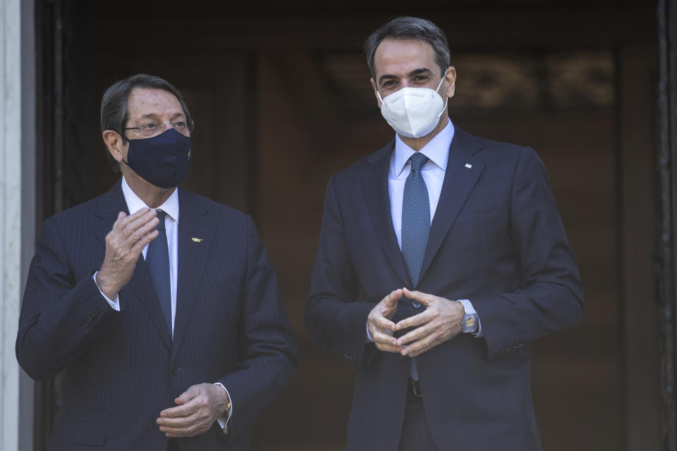 Greece's Prime Minister Kyriakos Mitsotakis, right, welcomes Cypriot President Nicos Anastasiades before their meeting at Maximos Mansion in Athens,Wednesday, April 21, 2021. (AP Photo/Petros Giannakouris)