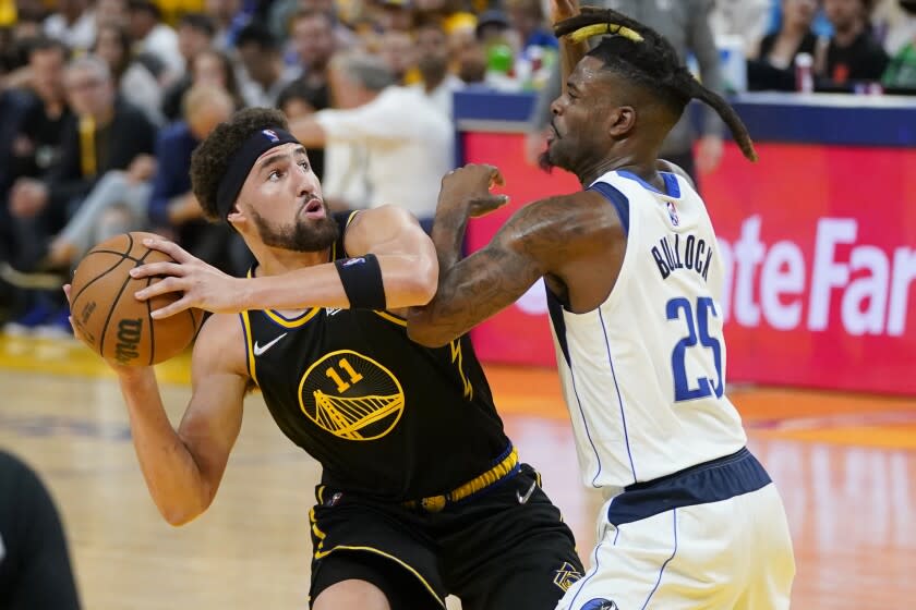 Golden State Warriors guard Klay Thompson (11) is defended by Dallas Mavericks guard Reggie Bullock (25) during the first half in Game 5 of the NBA basketball playoffs Western Conference finals in San Francisco, Thursday, May 26, 2022. (AP Photo/Jeff Chiu)
