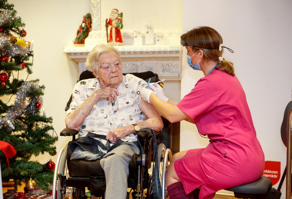 Nurse Ann-Louise Broberg injects the coronavirus disease (COVID-19) vaccine to nursing home resident Gun-Britt Johnsson, the first person to receive it in the country, in Mjolby, Sweden, December 27, 2020. Stefan Jerrevang/TT News Agency/via REUTERS      ATTENTION EDITORS - THIS IMAGE WAS PROVIDED BY A THIRD PARTY. SWEDEN OUT. NO COMMERCIAL OR EDITORIAL SALES IN SWEDEN.