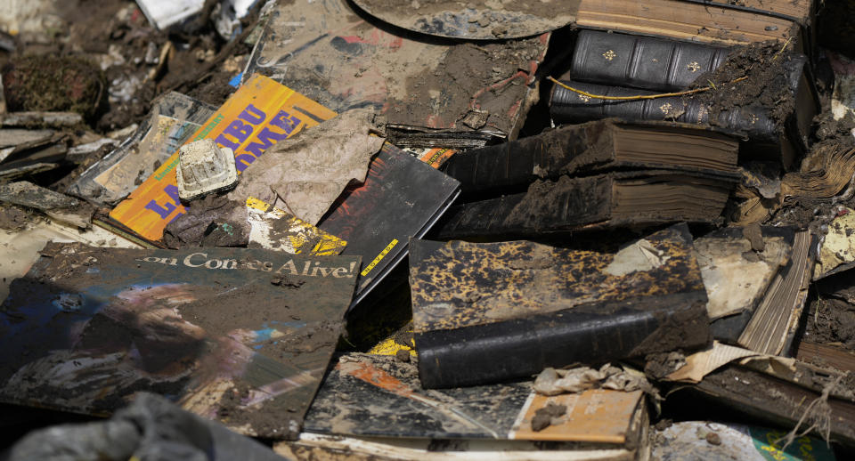 Record albums, books and other personal effects lay damaged by floodwaters in Purgatoire, Belgium, Saturday, July 17, 2021. The Walloon government, has announced a 2 billion euro plan for reconstruction in the storm hit region but money alone won't cover for all the losses suffered by the region. For many residents the trauma they experienced will forever stay in their minds. (AP Photo/Virginia Mayo)