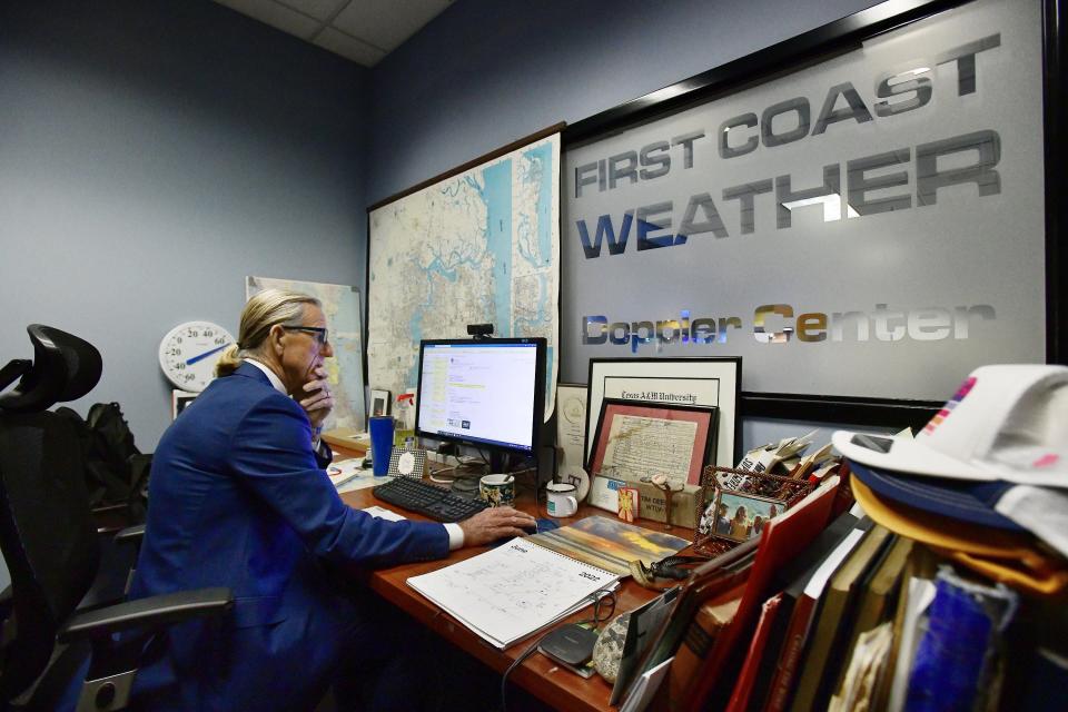 First Coast News chief meteorologist Tim Deegan works at one of his desks where he says he spends more time producing content for online than at his other desk where he puts together his broadcast weather segments.