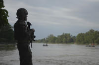 A Mexican marine stands guard on the Suchiate River, watching out for migrants crossing from Guatemala to Ciudad Hidalgo, Mexico, Sunday, June 16, 2019. Mexico faces heightened pressure from the U.S. to reduce the surge of mostly Central American migrants through its territory. (AP Photo/Idalia Rie)