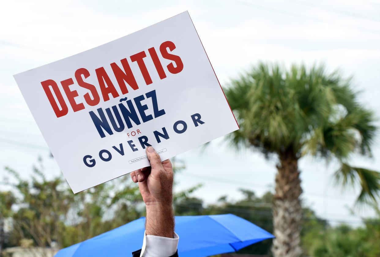 A supporter of Florida GOP gubernatorial nominee Ron DeSantis waves a sign at a 2018 campaign rally.