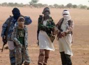 Fighters of the Islamist group Ansar Dine stand in Kidal as Burkina Faso's foreign minister Djibrille Bassole meets with the group's leader on August 7, 2012. One of the main Islamist groups in Mali split Thursday, with the breakaway faction saying it was ready for talks to end a two-week-old French-led offensive, amid mounting concerns over rights abuses by government troops