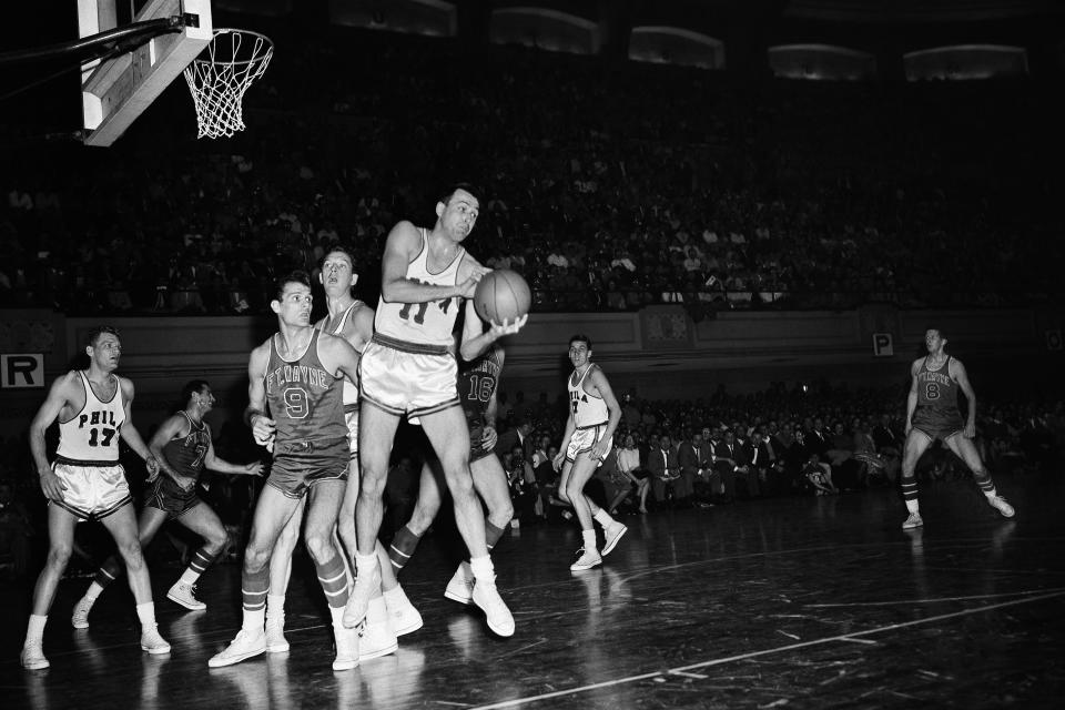 FILE – In this April 8, 1956, file photo, Philadelphia Warriors’ Paul Arizin (11) grabs a rebound as Mel Hutchins (9) of the <a class="link " href="https://sports.yahoo.com/nba/teams/detroit/" data-i13n="sec:content-canvas;subsec:anchor_text;elm:context_link" data-ylk="slk:Fort Wayne Pistons;sec:content-canvas;subsec:anchor_text;elm:context_link;itc:0">Fort Wayne Pistons</a> stands near in Philadelphia. (AP Photo/File)