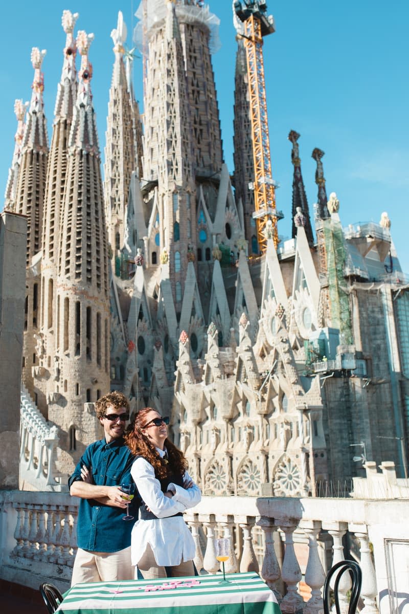 Dwellers pose on their patio overlooking The Basílica Temple Expiatori de la Sagrada Família
