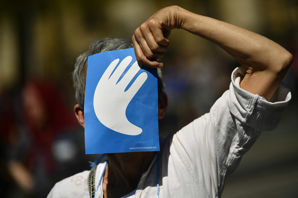 <p>A pro independence Basque follower covers her face with the symbol of the day called ”Artisans of the Peace”, during a meeting after the announcement that ETA handed over its arms in Bayonne, southwestern France, April 8, 2017. The Basque separatist group ETA, inactive for more than five years, handed over its arms Saturday, putting a finishing touch to a 43-year violent campaign that claimed the lives of over 800 people mostly in Spain. (Photo: Alvaro Barrientos/AP) </p>