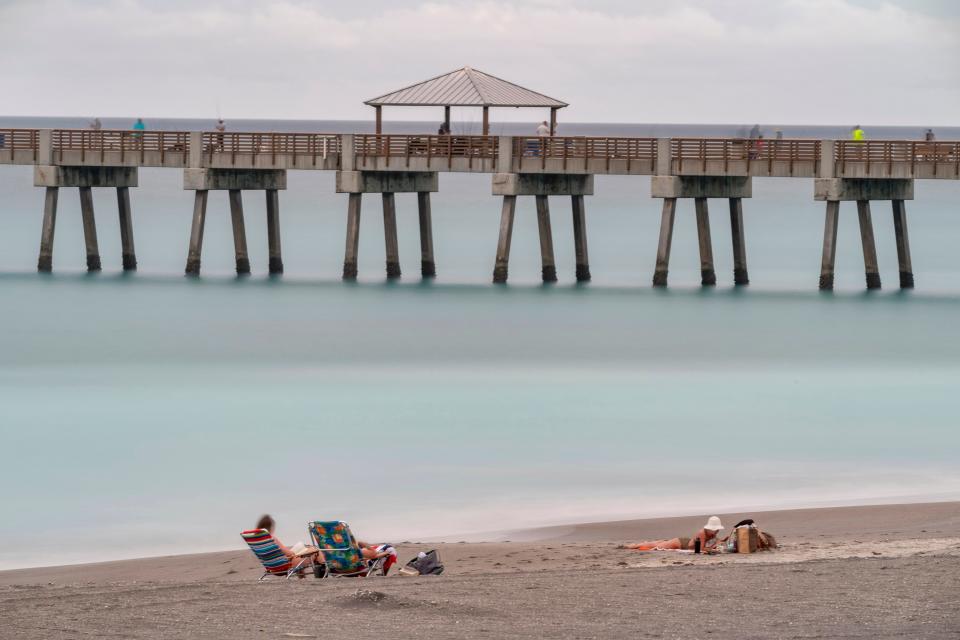 Beachgoers lounge near the Juno Beach Pier.