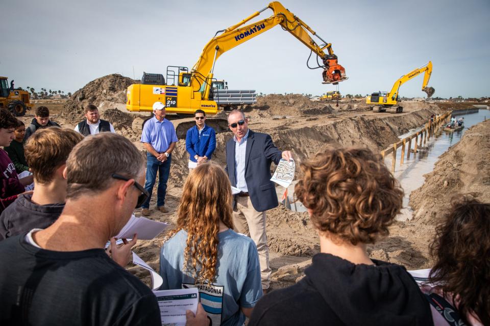 Flour Bluff STEM students on a field trip gather around Jeff Coym, LJA Engineering vice president, while he explains a master planned community and preserve project on North Padre Island, Wednesday, Jan. 31, 2024, in Corpus Christi, Texas.