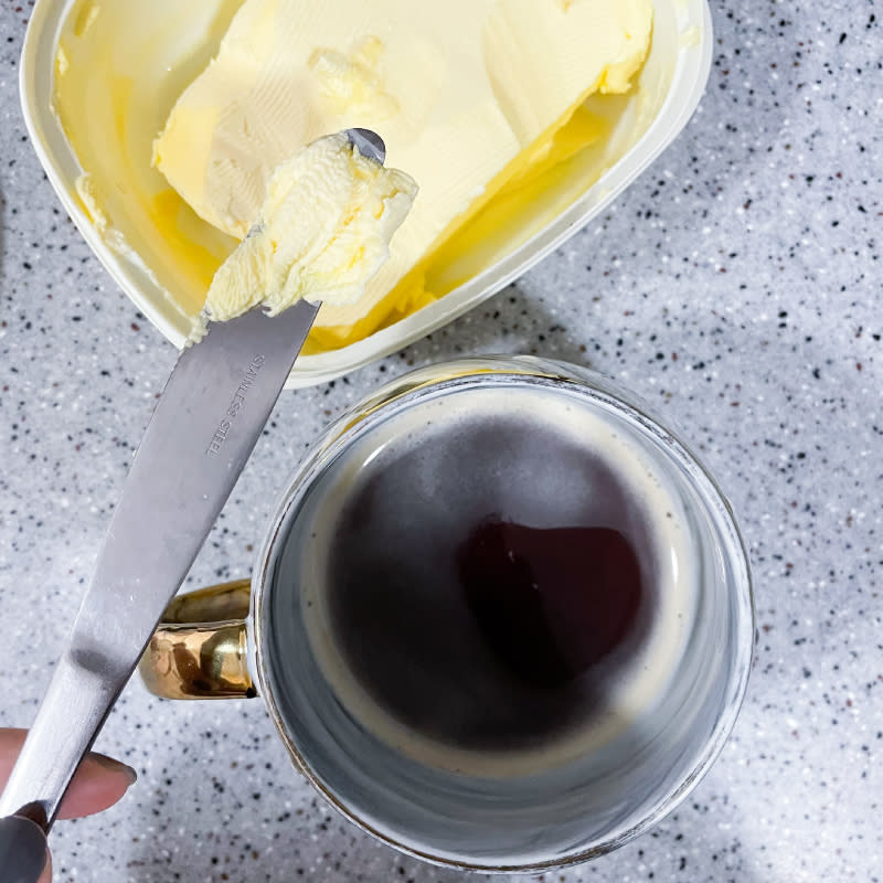 a hand in frame shot of butter and coffee