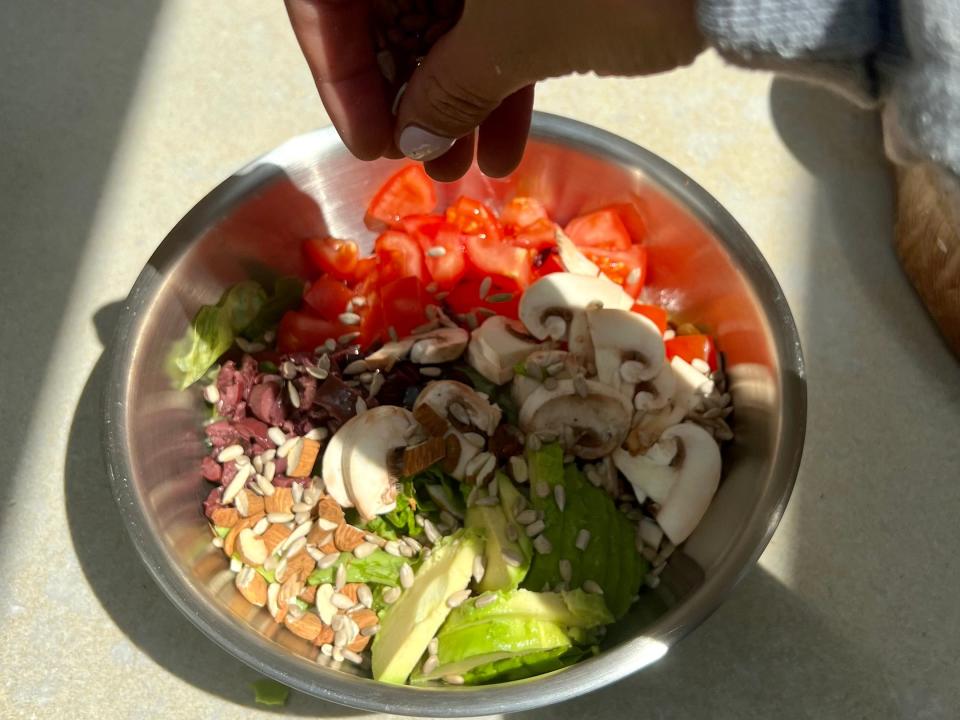 Topping the salad off with sunflower seeds.