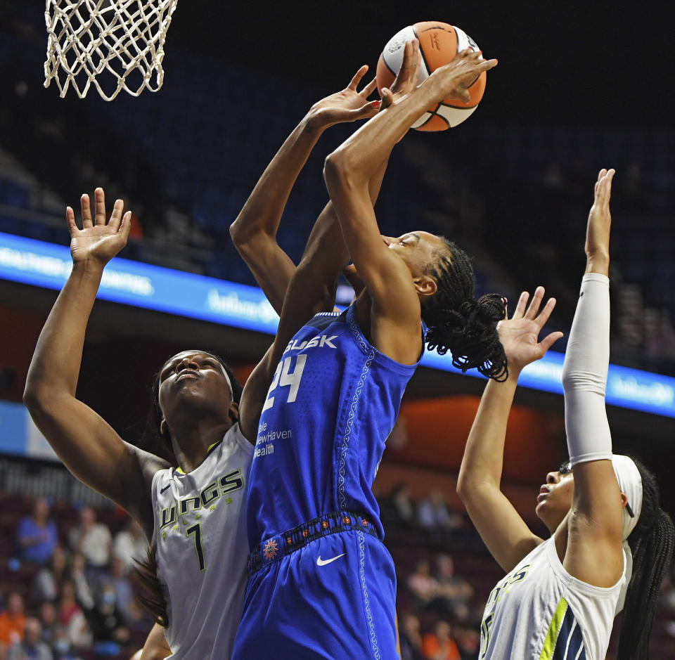 Dallas Wings center Teaira McCowan (7) fouls Connecticut Sun forward DeWanna Bonner (24) on a drive to the basket during the first half of a WNBA basketball game Tuesday, May 24, 2022 at Mohegan Sun Arena in Uncasville, Conn. (Sean D. Elliot/The Day via AP)