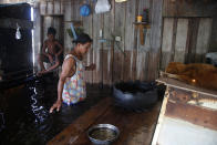 Raimundo da Silva Reis walks in his house, flooded by the rise of the Negro river in Iranduba, Amazonas state, Brazil, Monday, May 23, 2022. The Amazon region is being hit hard by flooding with 35 municipalities that are facing one of their worst floods in years and the water level is expected to rise over the coming months. (AP Photo/Edmar Barros)