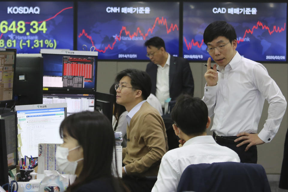 Currency traders work at the foreign exchange dealing room of the KEB Hana Bank headquarters in Seoul, South Korea, Wednesday, Feb. 26, 2020. Asian shares slid Wednesday following another sharp fall on Wall Street as fears spread that the growing virus outbreak will put the brakes on the global economy.(AP Photo/Ahn Young-joon)