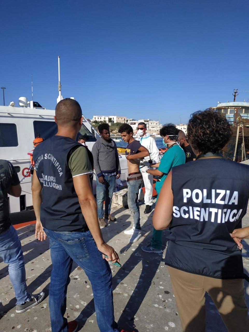 Migrants disembarked from the Open Arms Spanish humanitarian boat arrive in the harbor of the Sicilian island of Lampedusa, southern Italy, Saturday, Aug.17, 2019. Italy’s hard-line interior minister buckled under pressure Saturday and agreed to let 27 unaccompanied minors leave a migrant rescue ship after two weeks at sea, temporarily easing a political standoff that has threatened the viability of the populist government. (Concetta Rizzo/ANSA Via AP)