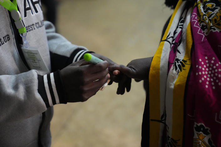 An election official marks the hand of a voter at the Kibera primary school in Nairobi, Kenya, Tuesday Aug. 9, 2022. Kenyans are voting to choose between opposition leader Raila Odinga and Deputy President William Ruto to succeed President Uhuru Kenyatta after a decade in power. (AP Photo/Mosa'ab Elshamy)