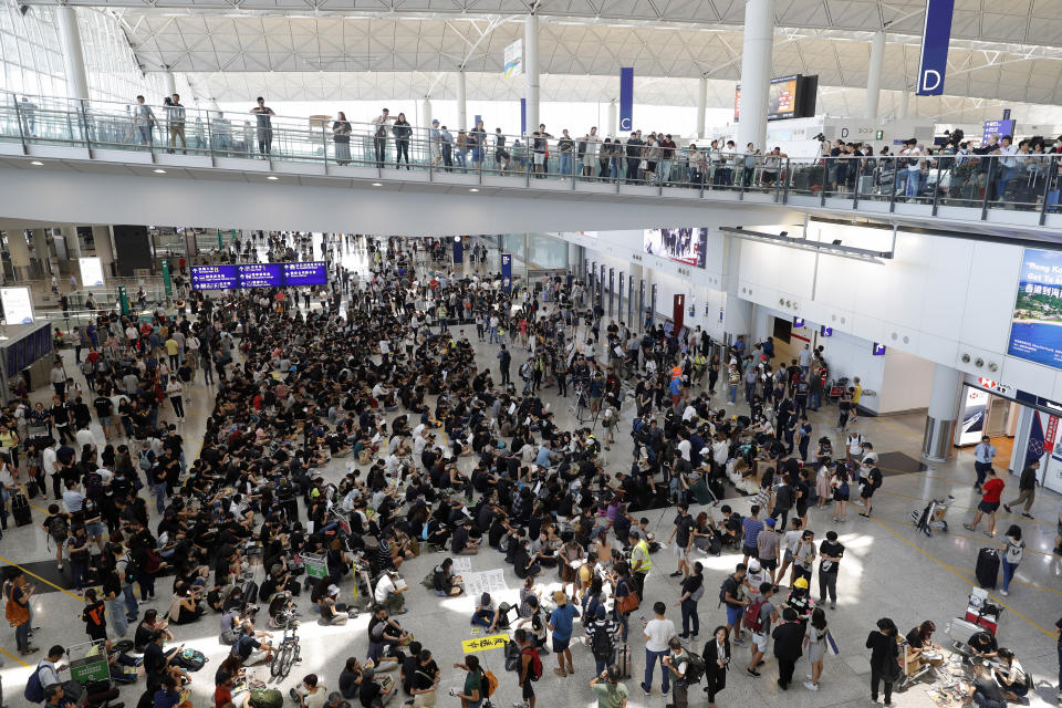 Protesters demonstrate at the airport in Hong Kong on Friday, Aug. 9, 2019. Pro-democracy protesters held a demonstration at Hong Kong's airport Friday even as the city sought to reassure visitors to the city after several countries issued travel safety warnings related to the increasing levels of violence surrounding the two-month-old protest movement. (AP Photo/Vincent Thian)