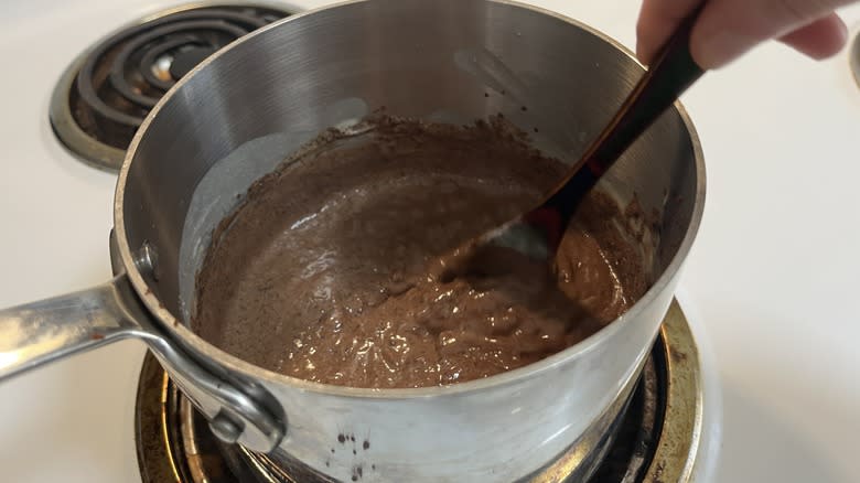 hand stirring chocolate rice pudding with a spoon