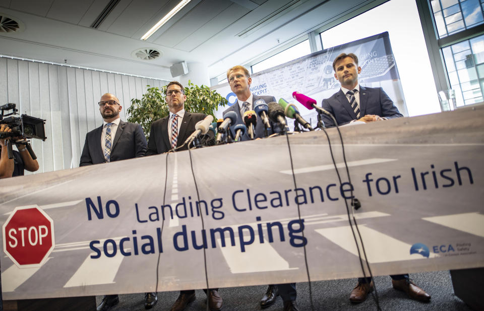 Markus Wahl, Vice President of the Vereinigung Cockpit (VC), VC President Martin Locher, Ingolf Schumacher, VC's head of wage policy and spokesperson Janis Schmitt, from left, stand behind a banner reading 'No Landing Clearance for Irish social dumping' during a press conference in Frankfurt, Germany, Wednesday, Aug. 8, 2018 when announcing a 24hours strike of the German Ryanair pilots on Friday. (Frank Rumpenhorst/dpa via AP)