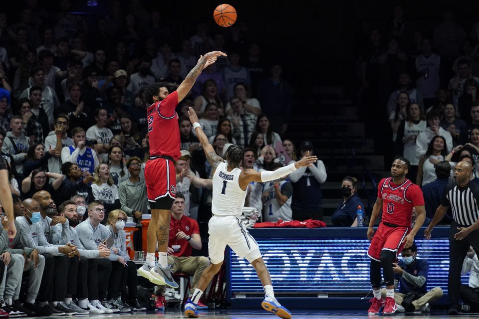 St. John's guard Julian Champagnie (2) shoots over Xavier's Paul Scruggs (1) during the second half of an NCAA college basketball game, Wednesday, Feb. 16, 2022, in Cincinnati.