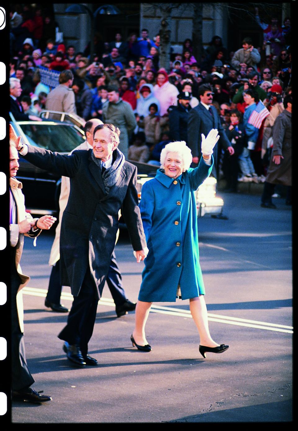 Barbara Bush and husband George H. W. Bush hold hands during his 1989 inaugural parade.