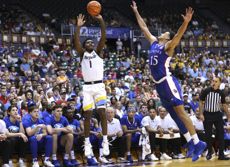 Marquette guard Kam Jones (1) shoots against Kansas guard Kevin McCullar Jr. (15) during the first half of an NCAA college basketball game Tuesday, Nov. 21, 2023, in Honolulu. (AP Photo/Marco Garcia)