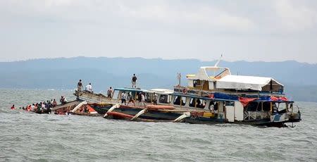 Passengers of the capsized MBCA Kim-Nirvana ferry (far L) are rescued by a tugboat of the Philippine coast guard near a port in Ormoc city, central Philippines July 2, 2015. REUTERS/Ronald Frank Dejon