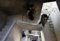 Free Syrian Army fighters carry their weapons as they walk down a building in the old city of Aleppo September 10, 2013. REUTERS/Nour Kelze