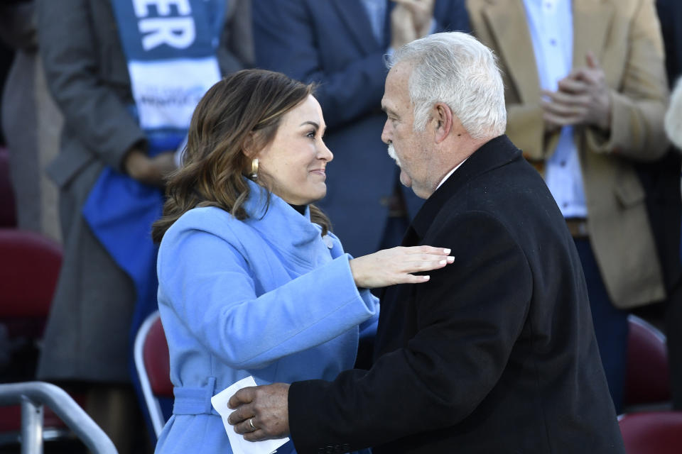 Kentucky Lt. Governor Jacqueline Coleman, left, is hugged by her father Jack Coleman as he introduced her to the audience gathered on the steps of the Kentucky State Capitol to witness her public swearing in ceremony in Frankfort, Ky., Tuesday, Dec. 12, 2023. (AP Photo/Timothy D. Easley)