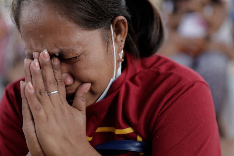 A woman displaced by Taal Volcano's eruption becomes emotional as she prays during a Catholic mass in an evacuation center