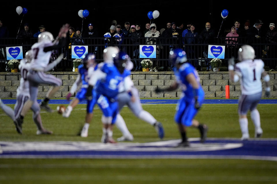 The names of the victims of the Lewiston shootings hang on the fence as Lewiston High School and Edward Little High School play football, Wednesday, Nov. 1, 2023, in Lewiston, Maine. Locals seek a return to normalcy after the mass shooting on Oct. 25. (AP Photo/Matt York)