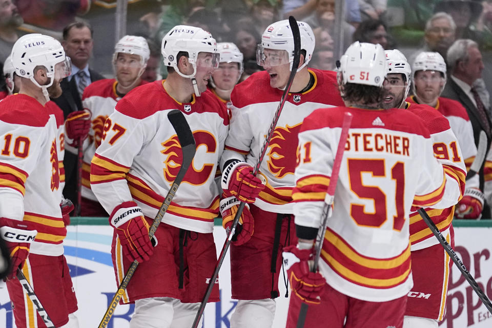 Calgary Flames' Jonathan Huberdeau (10), Nick Ritchie, Nikita Zadorov, center, Troy Stecher (51) and Nazem Kadri (91) celebrate after a score by Zadorov in the second period of an NHL hockey game, Monday, March 6, 2023, in Dallas. (AP Photo/Tony Gutierrez)