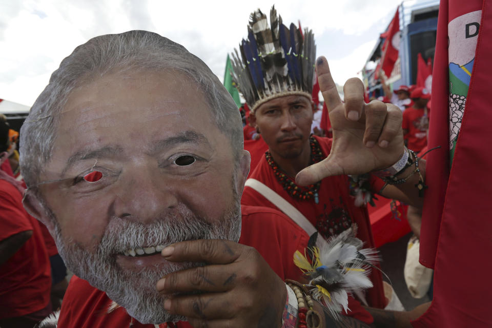 Supporters holding masks of Brazil's jailed former president Luiz Inacio Lula da Silva take part in the Free Lula March, in Brasilia, Brazil, Wednesday, Aug.15 2018. Thousands of supporters of the jailed leader and a current presidential candidate, are in Brasilia to monitor the registration of Lula's presidential candidacy, which will be held today by the Workers' Party in the Superior Electoral Court. (AP Photo/Eraldo Peres)